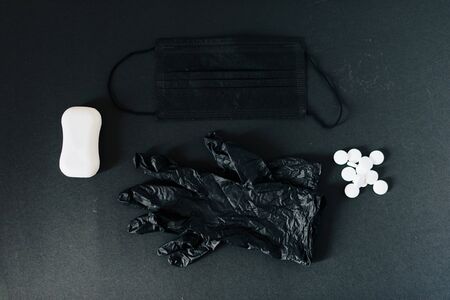 Black medical mask and black gloves on a black background 1の写真素材