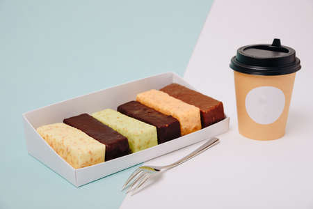 Set of cakes in icing and chocolate on a light background