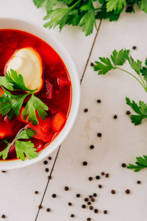 Borscht with fresh bread on a natural wooden background. Red beetroot soup with fresh breadの写真素材