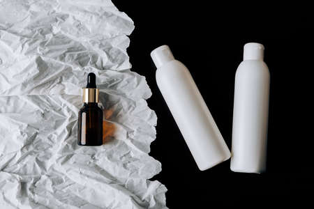 bottles of cosmetics on white crumpled paperの写真素材