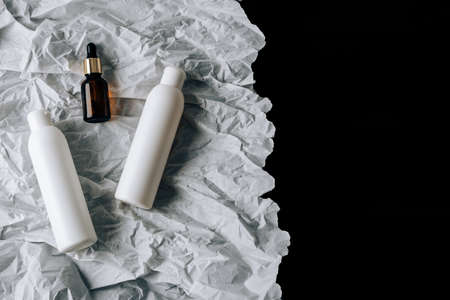 bottles of cosmetics on white crumpled paperの写真素材