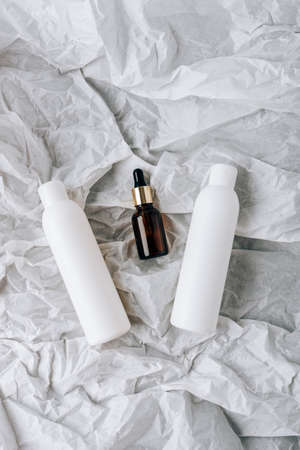 bottles of cosmetics on white crumpled paperの写真素材