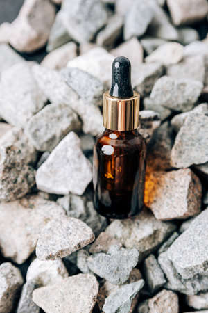 glass bottle with pipette on granite stonesの写真素材