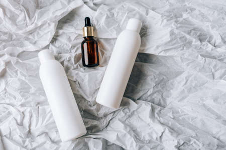 bottles of cosmetics on white crumpled paperの写真素材