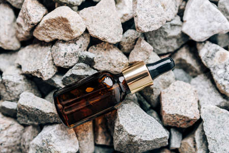 glass bottle with pipette on granite stonesの写真素材