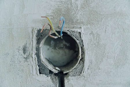 Holes in the concrete wall in the room for sockets