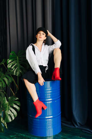 Portrait of a beautiful young woman in a white shirt and black pants in the Studioの写真素材