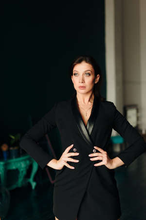 Beautiful young woman in black jacket at homeの写真素材