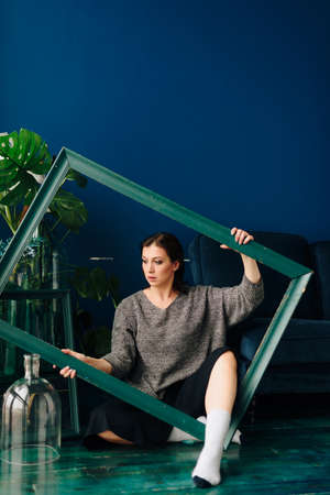Beautiful young woman in gray sweater and disco ball at home