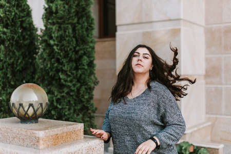 Portrait of a young adult girl on the background of a modern building