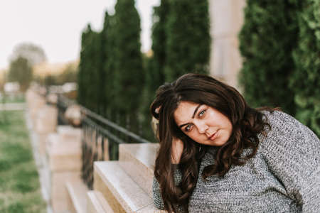 Portrait of a young adult girl on the background of a modern buildingの写真素材
