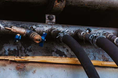 Black rubber hoses leading to the pipeの写真素材