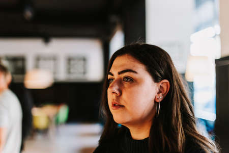 Portrait of a young adult girl on the background of a modern building