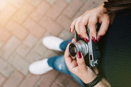 Young adult girl holding vintage camera outdoorsの写真素材