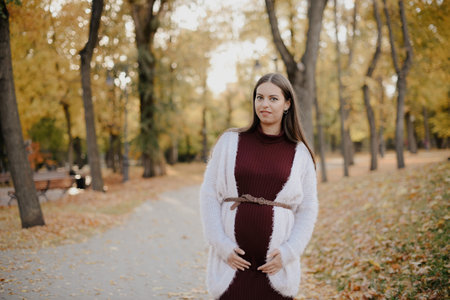 Young beautiful pregnant woman in city parkの写真素材