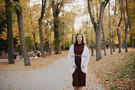 Young beautiful pregnant woman in city park