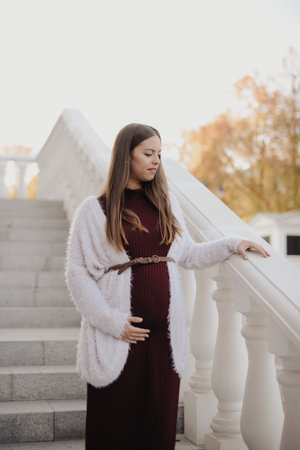 Young beautiful pregnant woman in city parkの写真素材