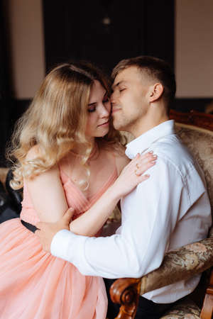 A young man and a woman embrace in a loft-style interior