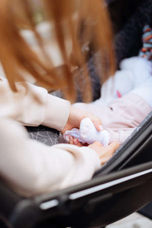 Babys legs and mothers hands close up