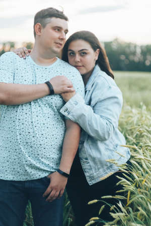 Young adult man and woman in a wheat fieldの写真素材