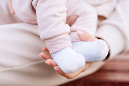 Baby's legs and mother's hands close upの写真素材