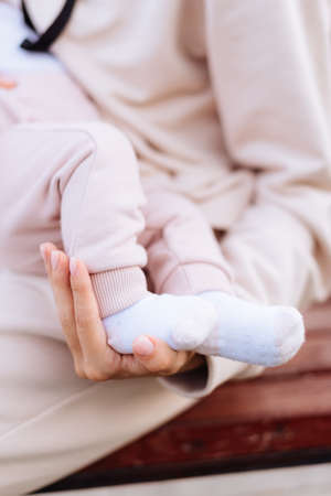 Baby's legs and mother's hands close upの写真素材