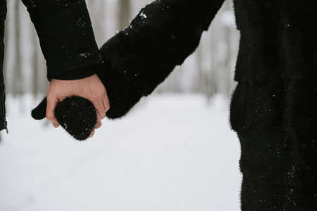 A man holds a womans hand in a mitten close-upの写真素材