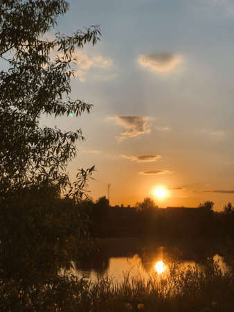 Magnificent sunset over the lake with fabulous cloudsの写真素材
