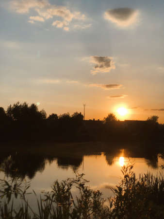 Magnificent sunset over the lake with fabulous cloudsの写真素材