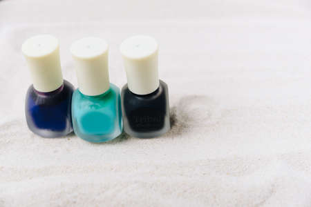 Colored nail polish on white sandの写真素材