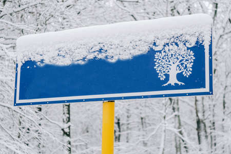 Blue sign on the background of a snowy forestの写真素材