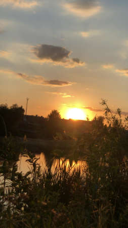 Magnificent sunset over the lake with fabulous cloudsの写真素材