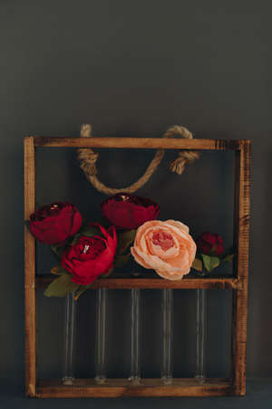Rosebuds in test tubes on the background of the wallの写真素材