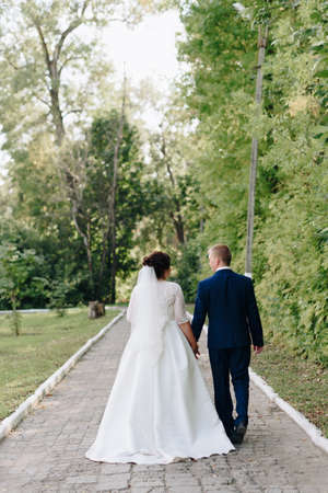 The newlyweds are walking in the summer parkの写真素材