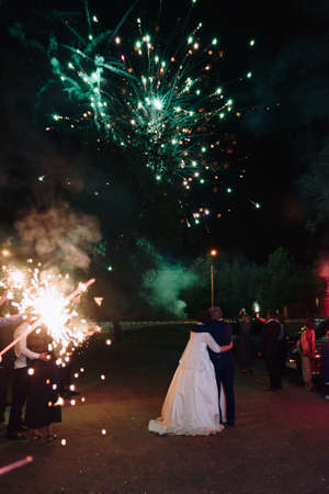 The newlyweds look at the fireworks in the night skyの写真素材