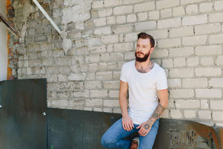 A handsome young man with a beard in a grunge-style interior 1の写真素材