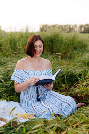Beautiful young woman in summer in a wheat fieldの写真素材
