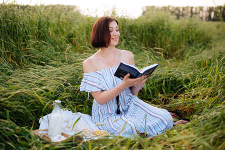 Beautiful young woman in summer in a wheat fieldの写真素材