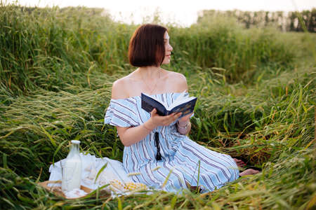 Beautiful young woman in summer in a wheat fieldの写真素材