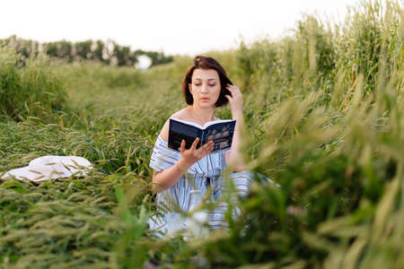 Beautiful young woman in summer in a wheat fieldの写真素材
