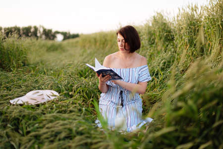 Beautiful young woman in summer in a wheat fieldの写真素材