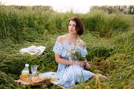 Beautiful young woman in summer in a wheat fieldの写真素材