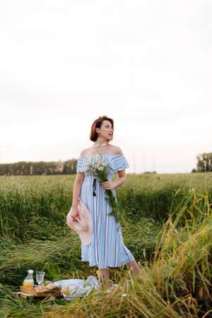 Beautiful young woman in summer in a wheat fieldの写真素材