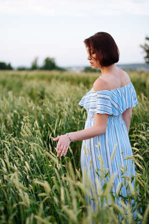 Beautiful young woman in summer in a wheat fieldの写真素材