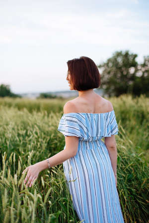 Beautiful young woman in summer in a wheat fieldの写真素材
