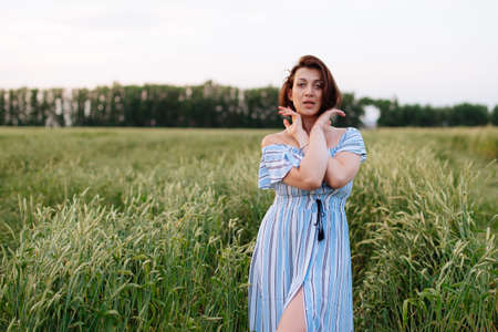 Beautiful young woman in summer in a wheat fieldの写真素材