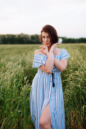 Beautiful young woman in summer in a wheat fieldの写真素材