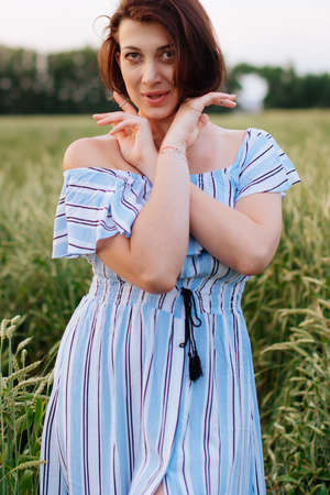 Beautiful young woman in summer in a wheat fieldの写真素材