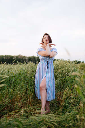 Beautiful young woman in summer in a wheat fieldの写真素材