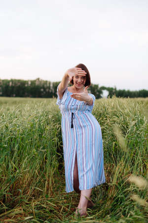 Beautiful young woman in summer in a wheat fieldの写真素材